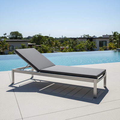 Premium poolside sun lounger, weather-resistant cushion, modern minimal design, pool water in background, sunny summer light, clean luxury aesthetic, ultra-realistic product shot, square 1:1, people, no text